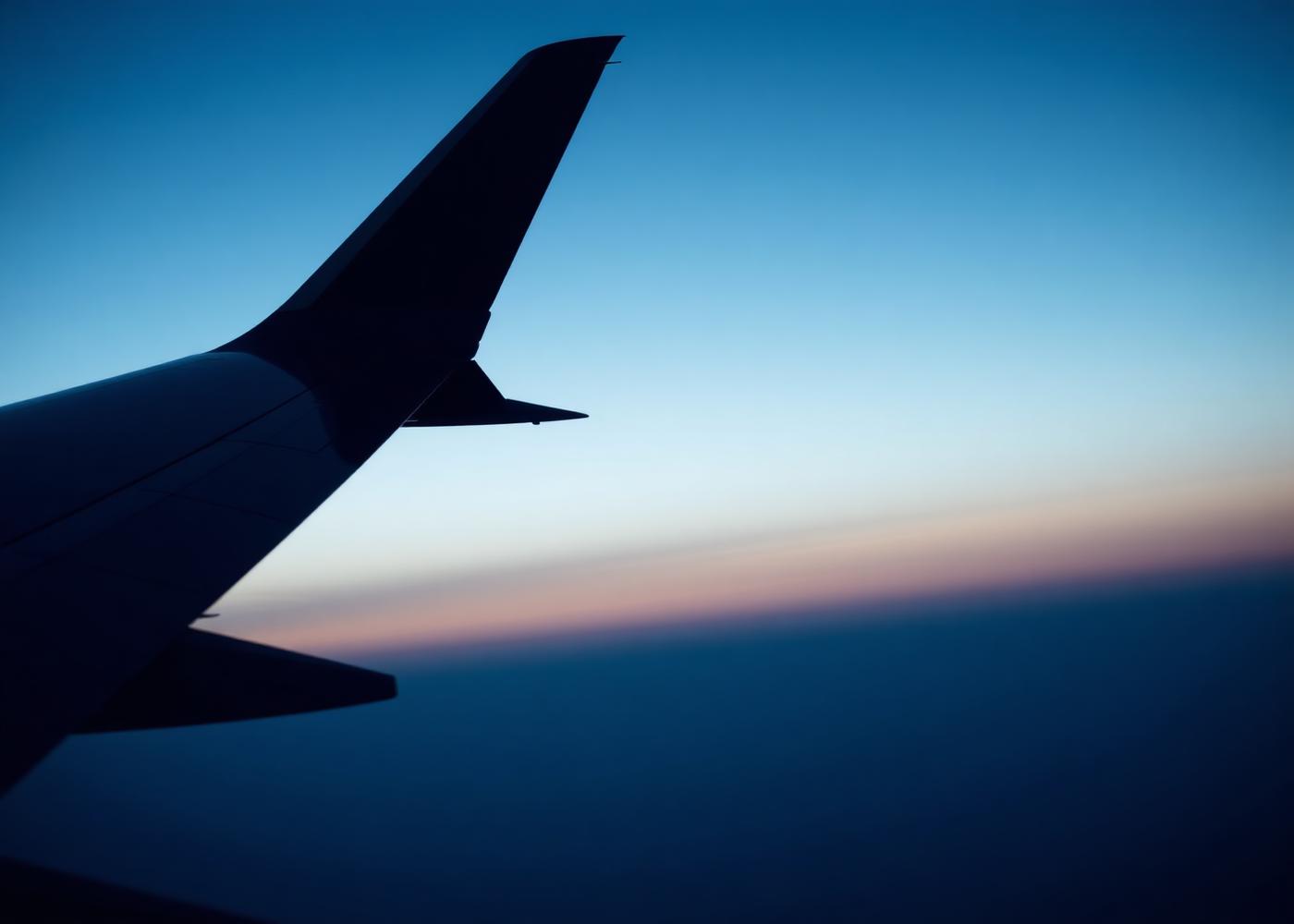 Business jet wingtip against a dawn sky